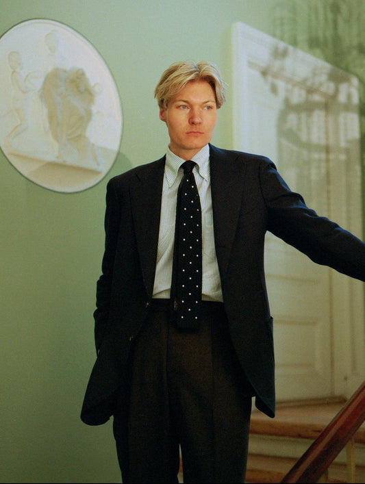 Man in a suit standing in a room with decorative wall art