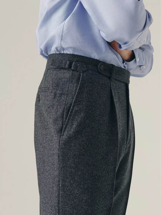 Grey pleated trousers worn with a light blue shirt