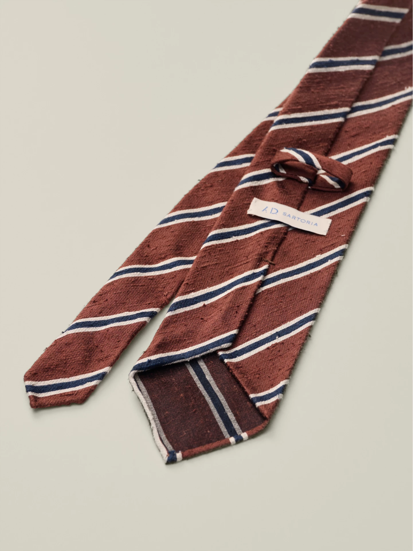 Striped red and blue tie with a brand label