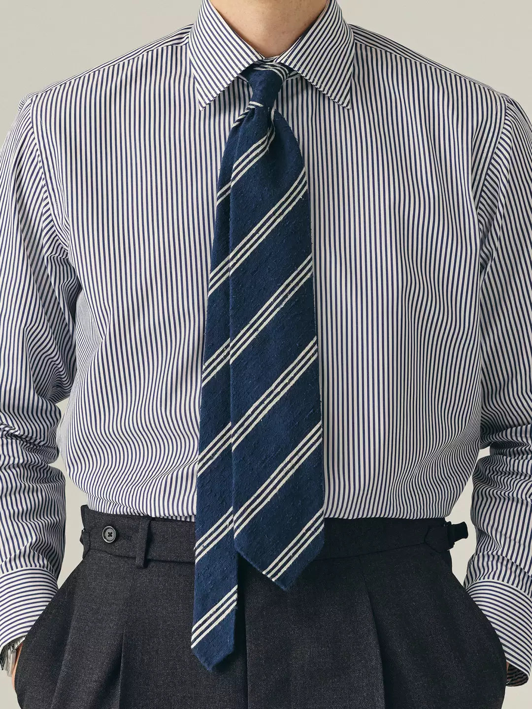 Person wearing a striped shirt with a blue & white striped tie