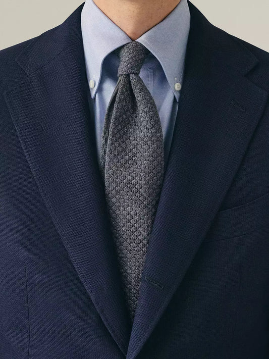 Person wearing Navy hopsack blazer blue shirt and grey tie