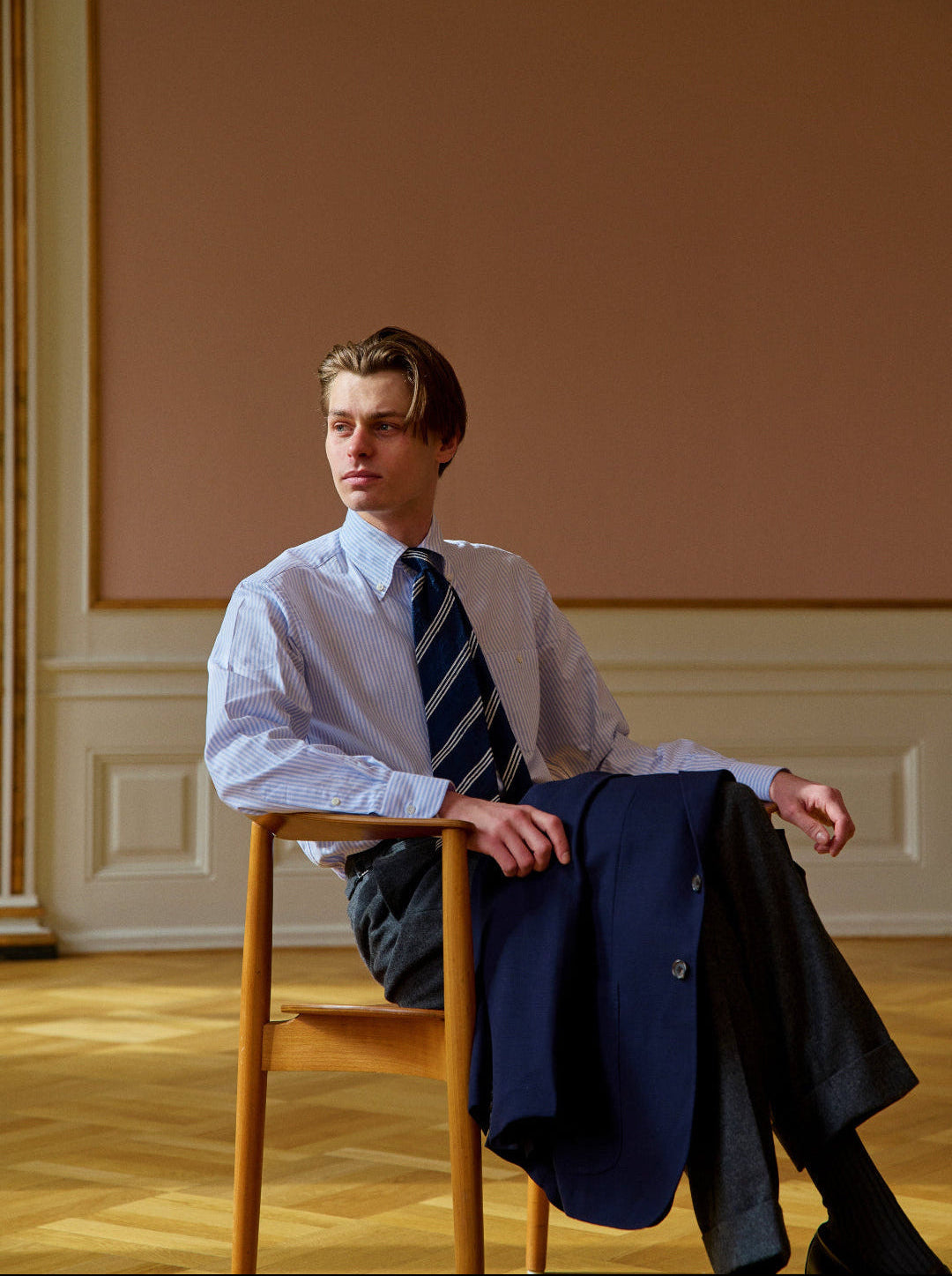 Man sitting on a chair in a room with a plain wall