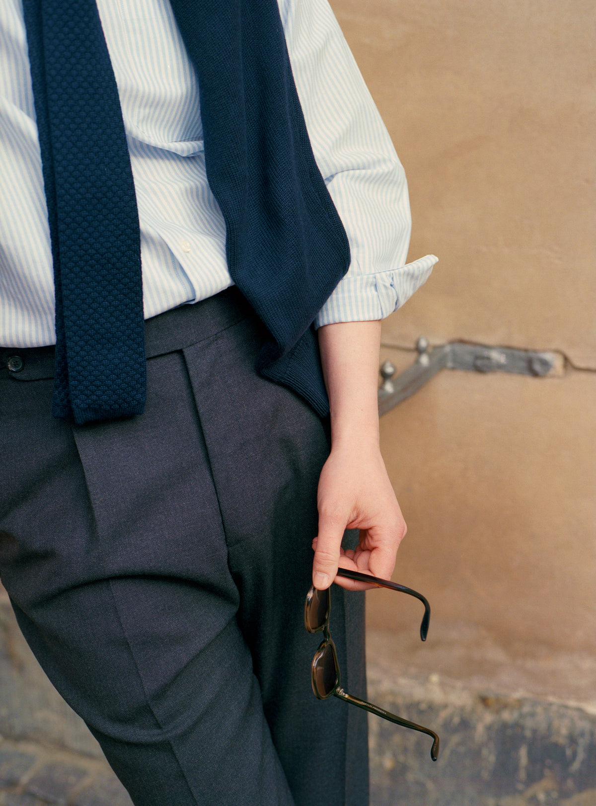 Person holding sunglasses with A. D. Sartoria cloth on.