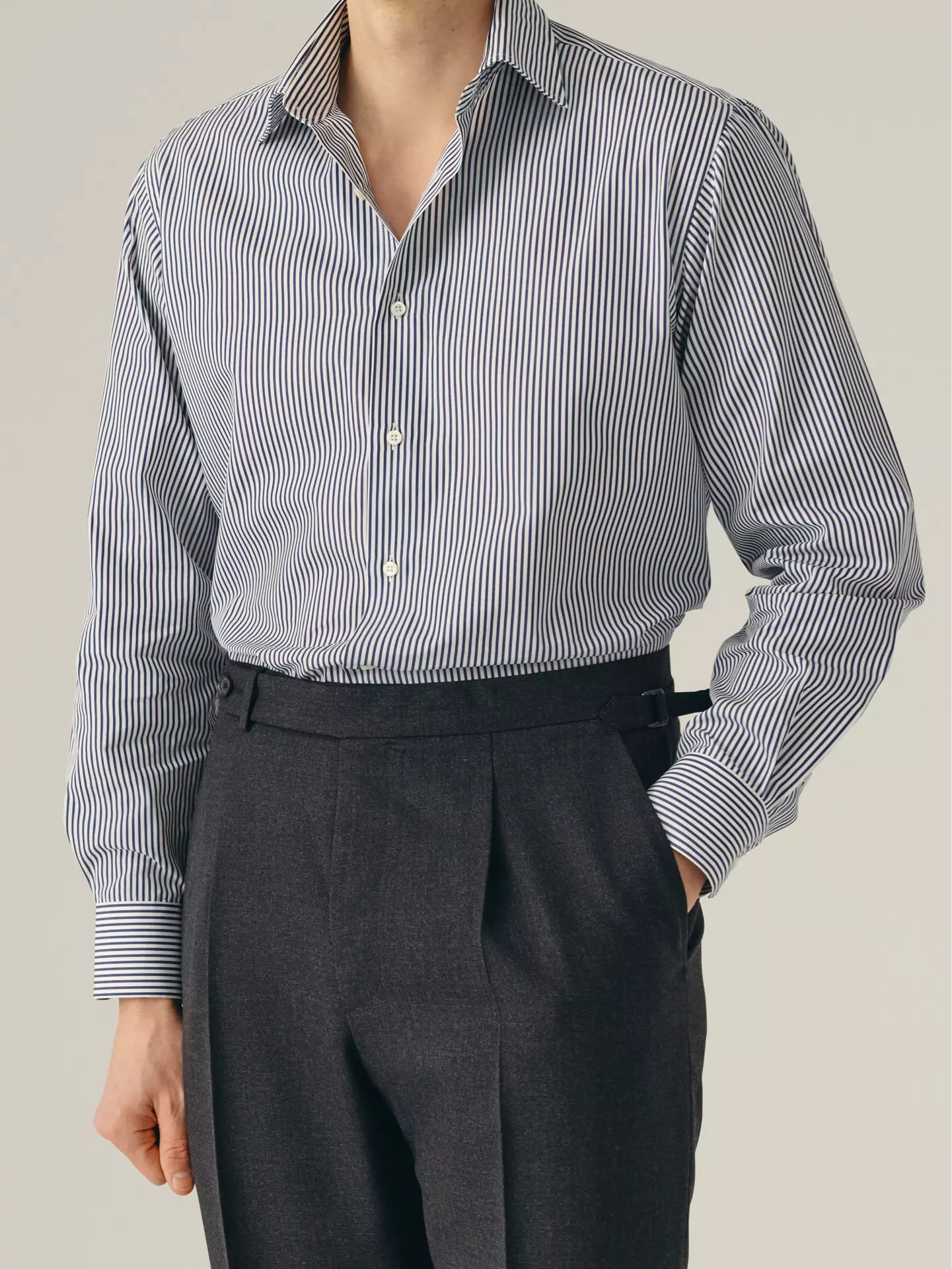 Person wearing a striped shirt and dark pants