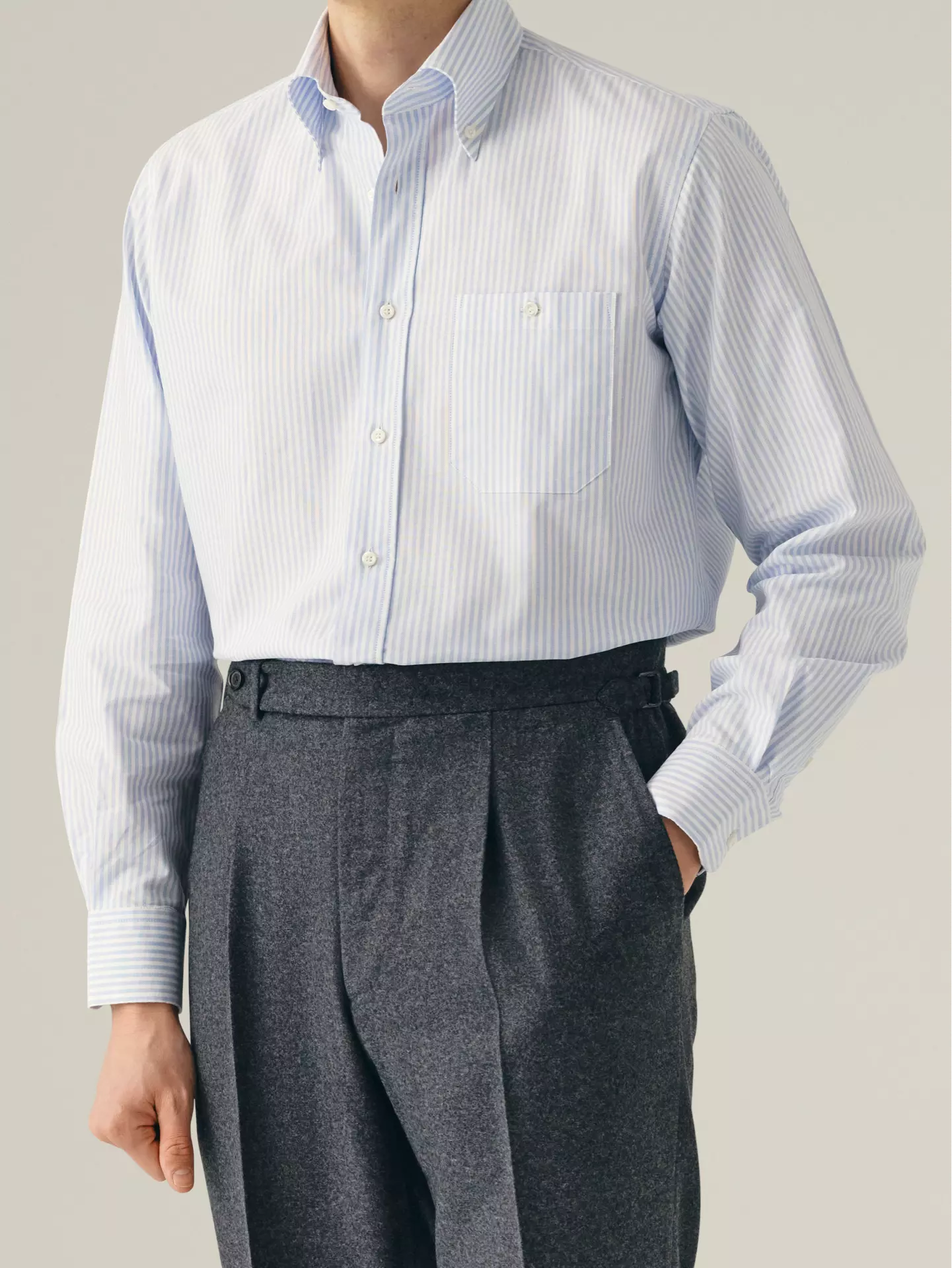 Person wearing a blue & white striped shirt with button down in oxford fabric 