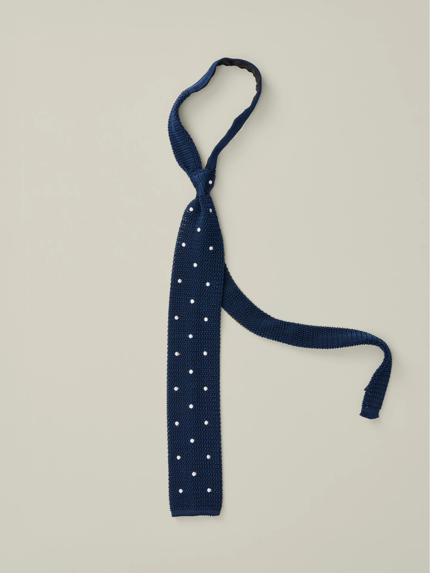 Blue knitted silk tie with white polka dots