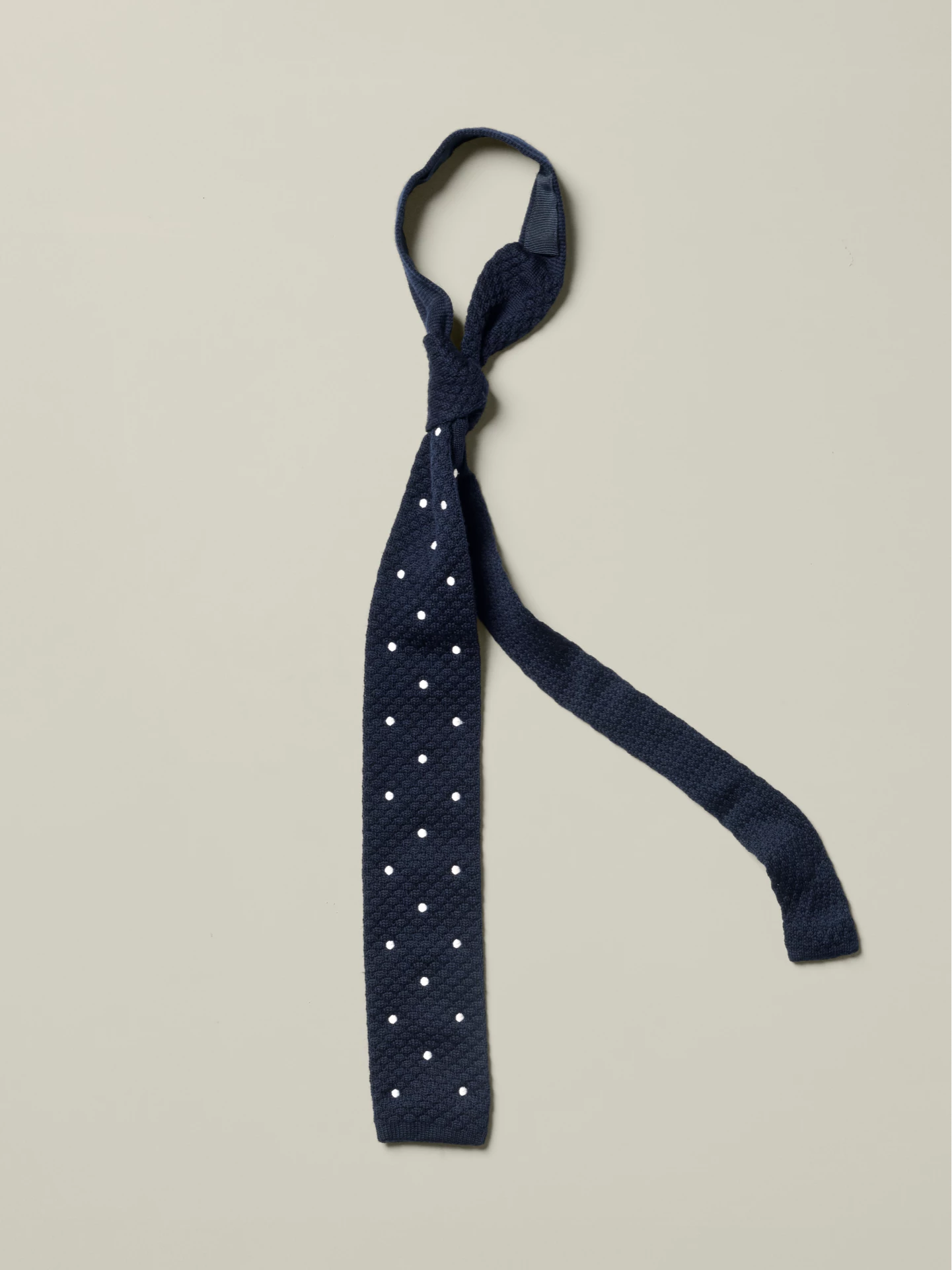 Blue knitted wool tie with white polka dots