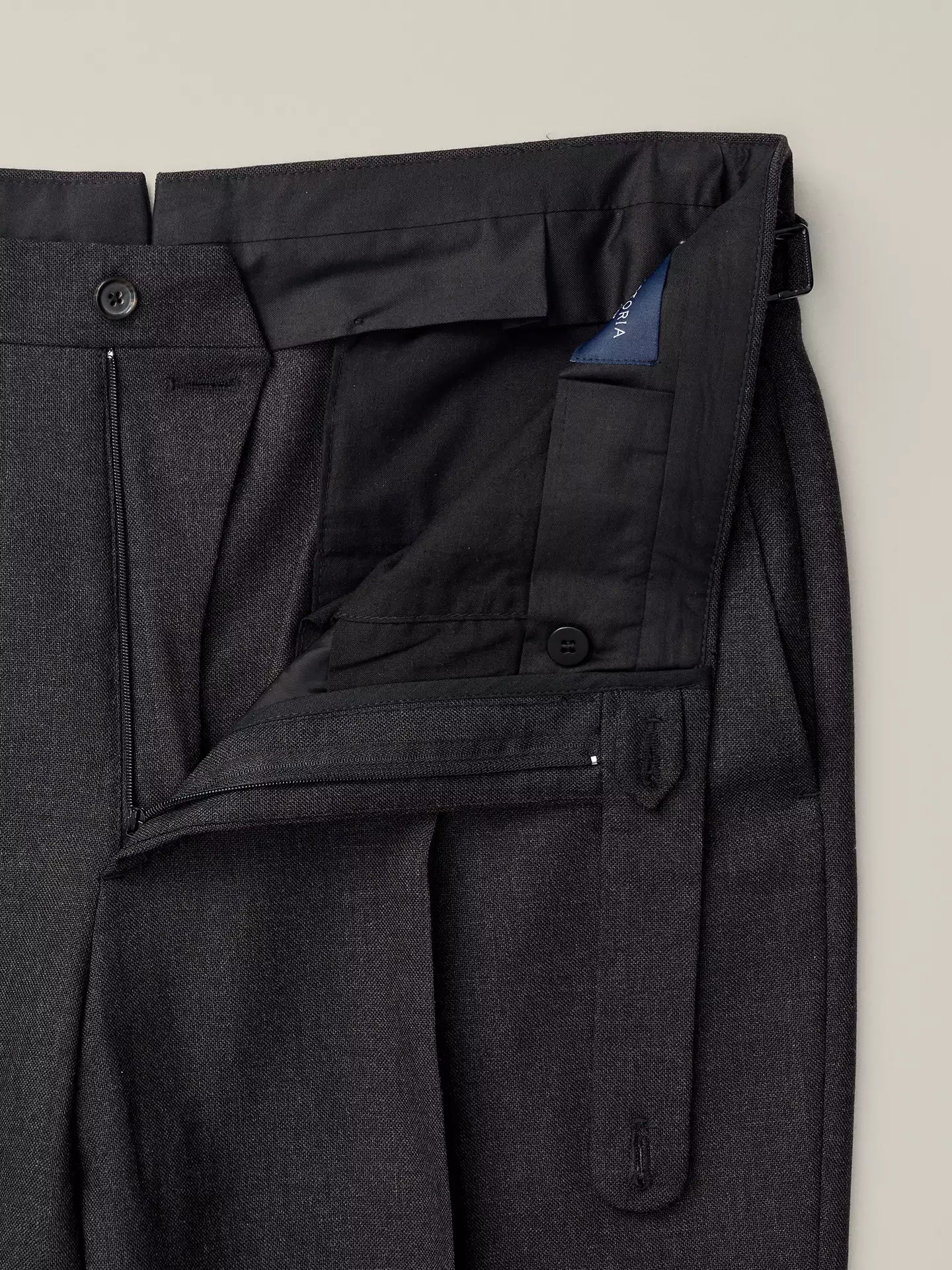 Dark grey trousers with a zipper and side adjuster 